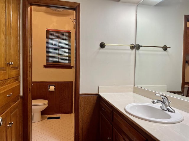 10900 Willow Grove Rd, Oklahoma City, OK 73120 - bathroom featuring wainscoting, toilet, vanity, tile patterned floors, and wooden walls