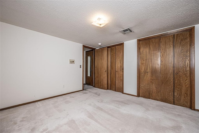 10900 Willow Grove Rd, Oklahoma City, OK 73120 - unfurnished bedroom featuring multiple closets, carpet, a textured ceiling, and baseboards