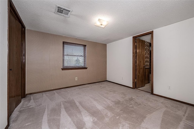 10900 Willow Grove Rd, Oklahoma City, OK 73120 - unfurnished bedroom featuring a textured ceiling, baseboards, and light colored carpet