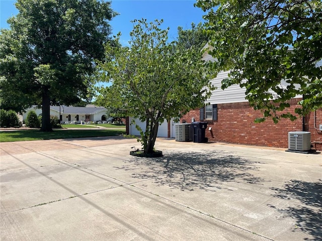 10900 Willow Grove Rd, Oklahoma City, OK 73120 - view of front of house featuring cooling unit, curved driveway, and brick siding
