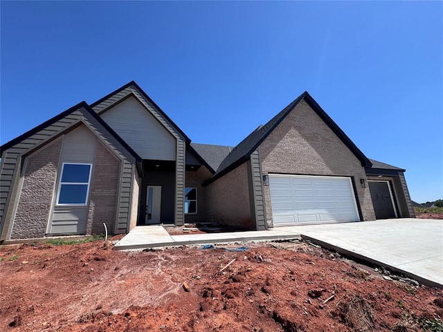single story home featuring a garage, concrete driveway, and brick siding