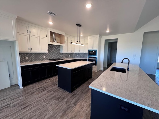 kitchen with visible vents, a center island with sink, custom range hood, a sink, and stainless steel appliances