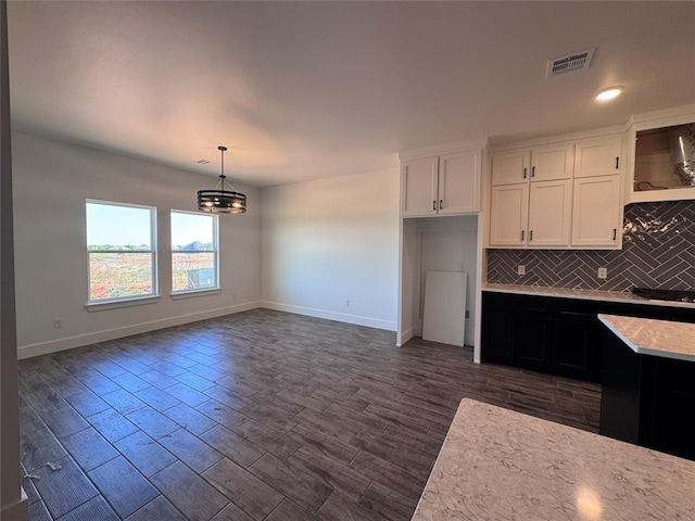 kitchen featuring visible vents, light countertops, white cabinetry, backsplash, and a notable chandelier