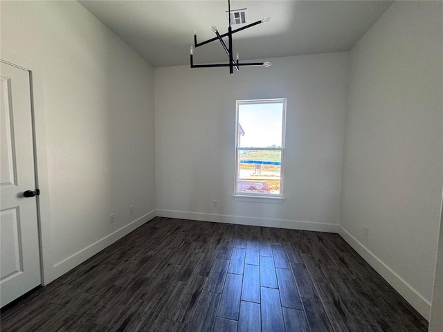 unfurnished dining area featuring dark wood-style flooring, baseboards, an inviting chandelier, and visible vents