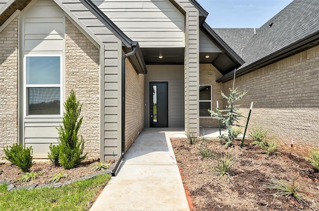 9321 NW 147th Ter, Yukon, OK 73099 - property entrance with a patio area, brick siding, and roof with shingles