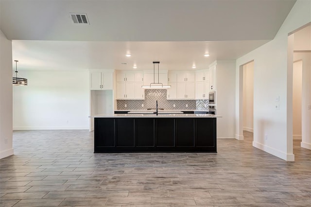 9321 NW 147th Ter, Yukon, OK 73099 - kitchen with light wood-style flooring, light countertops, white cabinetry, tasteful backsplash, and recessed lighting