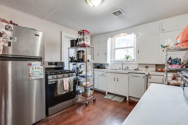 1011 NW 31st St, Oklahoma City, OK 73118 - kitchen featuring visible vents, dark wood-style flooring, light countertops, appliances with stainless steel finishes, and white cabinetry