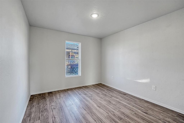 empty room featuring baseboards and wood finished floors