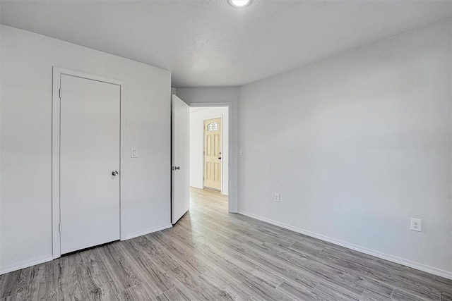 unfurnished bedroom with baseboards and wood finished floors