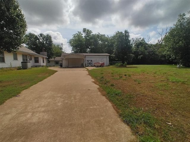 2005 E Cherokee Ave, Enid, OK 73701 - view of front of home with driveway, a carport, a front yard, and an outbuilding