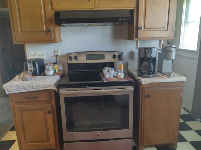 2005 E Cherokee Ave, Enid, OK 73701 - kitchen with electric stove, exhaust hood, light countertops, tile patterned floors, and brown cabinets