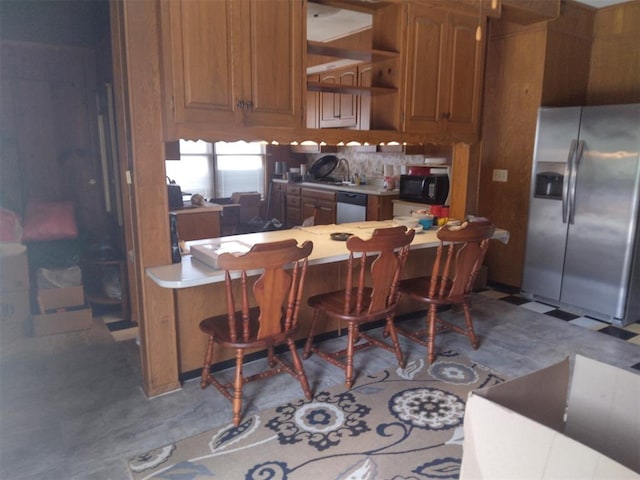 2005 E Cherokee Ave, Enid, OK 73701 - kitchen featuring appliances with stainless steel finishes, a breakfast bar, brown cabinets, light countertops, and open shelves