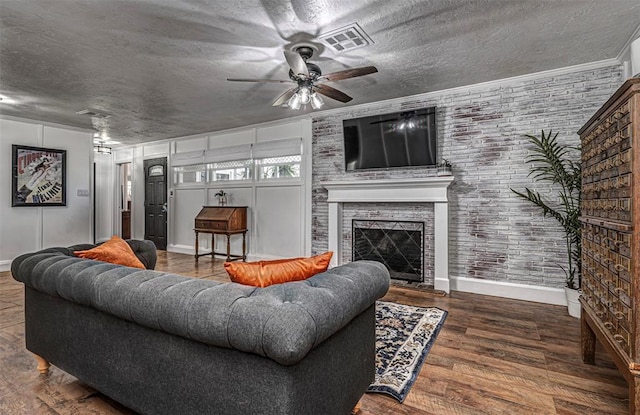 living area with wood finished floors, a ceiling fan, visible vents, and a textured ceiling