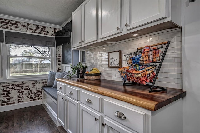 kitchen with backsplash, crown molding, butcher block countertops, a textured ceiling, and dark wood-style flooring