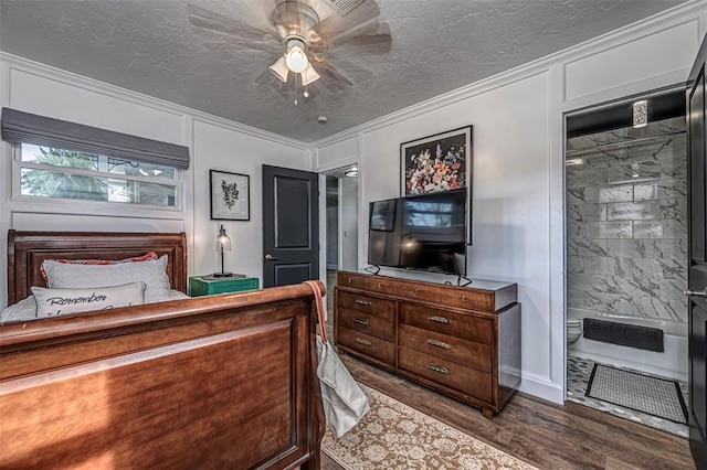 bedroom featuring a decorative wall, dark wood-style flooring, a textured ceiling, and ornamental molding