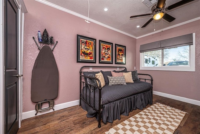 bedroom featuring visible vents, wood finished floors, baseboards, and ornamental molding