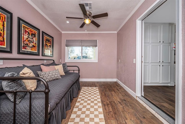 bedroom with baseboards, wood finished floors, and crown molding