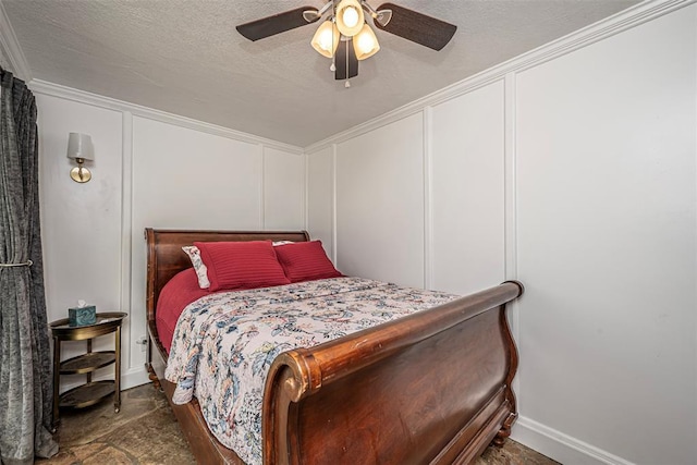 bedroom featuring a textured ceiling, ceiling fan, crown molding, and a decorative wall