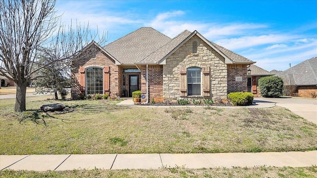 view of front of house with brick siding, stone siding, concrete driveway, and a front yard