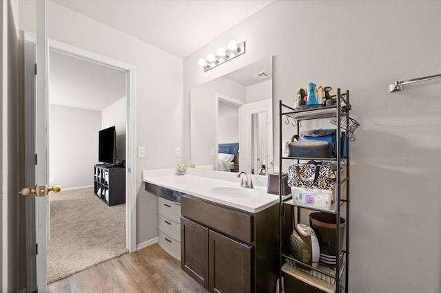 bathroom with visible vents, baseboards, wood finished floors, and vanity