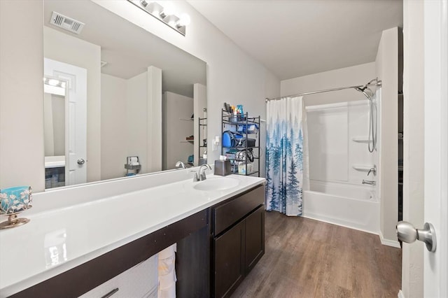 bathroom with visible vents, vanity, shower / tub combo, and wood finished floors