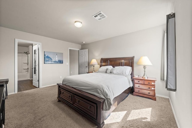 carpeted bedroom with baseboards, visible vents, and connected bathroom