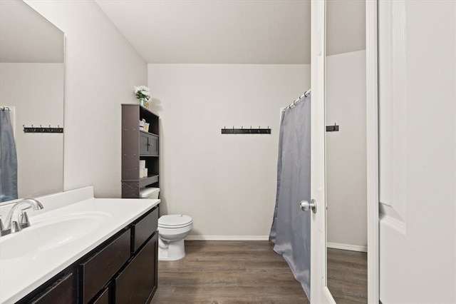 full bathroom featuring baseboards, toilet, wood finished floors, and vanity