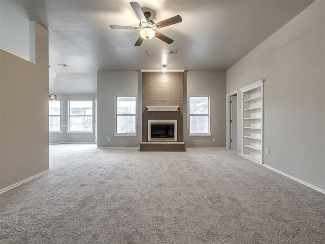 unfurnished living room featuring visible vents, baseboards, carpet floors, a fireplace, and a ceiling fan