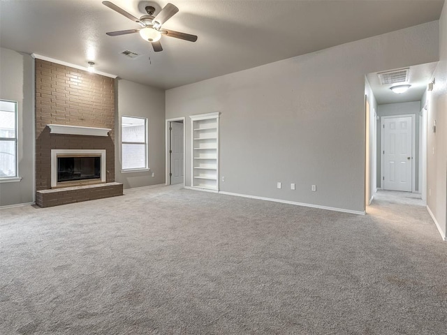 unfurnished living room featuring a wealth of natural light, visible vents, carpet flooring, and ceiling fan