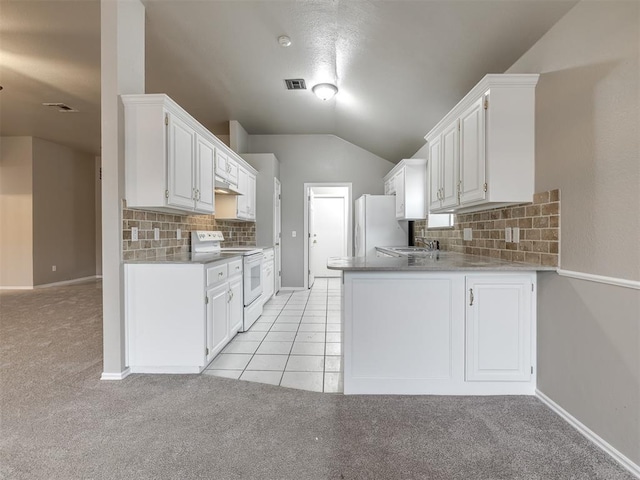 kitchen featuring white appliances, visible vents, lofted ceiling, a sink, and white cabinets