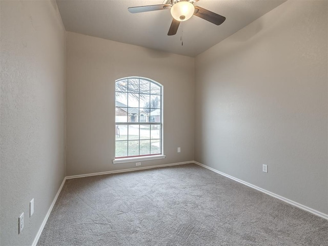 unfurnished room featuring carpet flooring, a textured wall, baseboards, and ceiling fan