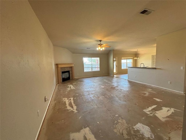 unfurnished living room with a ceiling fan, baseboards, visible vents, and a tiled fireplace