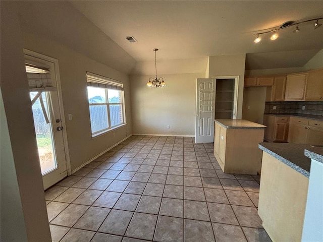 kitchen featuring visible vents, lofted ceiling, tasteful backsplash, light tile patterned floors, and a notable chandelier