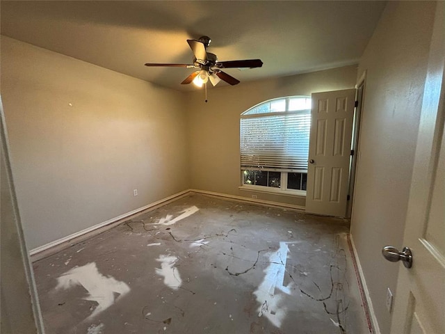 unfurnished room with ceiling fan and baseboards