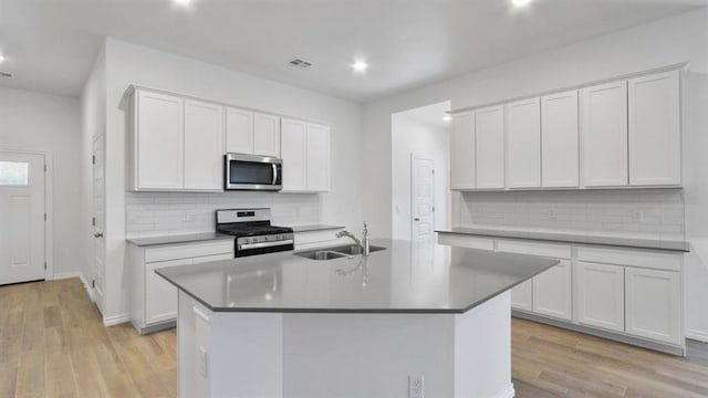 5502 Windstone Ln, Norman, OK 73072 - kitchen with stainless steel appliances, tasteful backsplash, recessed lighting, light wood-style floors, and a kitchen island with sink