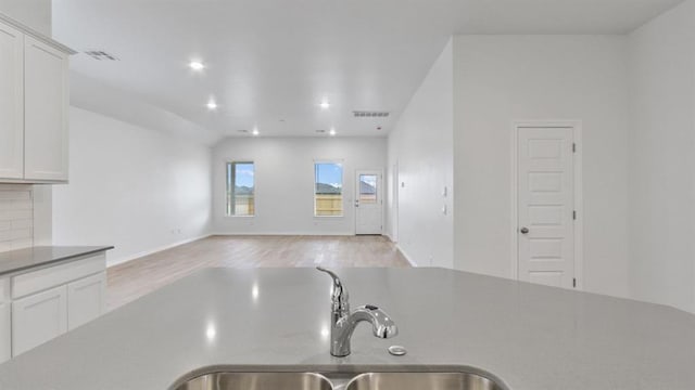 5502 Windstone Ln, Norman, OK 73072 - kitchen with light wood-style floors, white cabinetry, recessed lighting, open floor plan, and backsplash