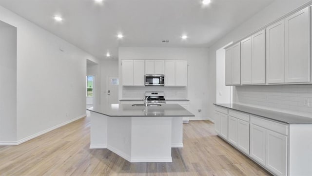 5502 Windstone Ln, Norman, OK 73072 - kitchen with stainless steel appliances, decorative backsplash, recessed lighting, light wood-style floors, and an island with sink