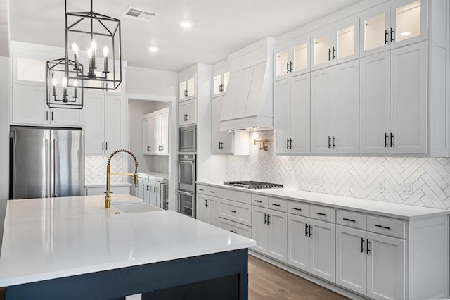 2215 Winter Creek Blvd, Blanchard, OK 73010 - kitchen featuring light countertops, custom exhaust hood, a notable chandelier, stainless steel appliances, and a sink