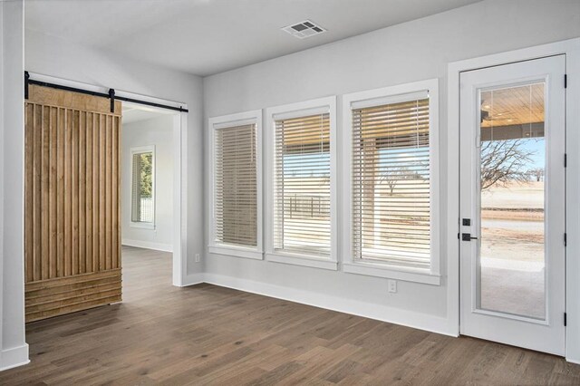 2215 Winter Creek Blvd, Blanchard, OK 73010 - interior space featuring a barn door, baseboards, visible vents, and dark wood-style flooring