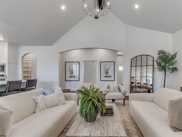 living area featuring arched walkways, wood finished floors, high vaulted ceiling, and recessed lighting