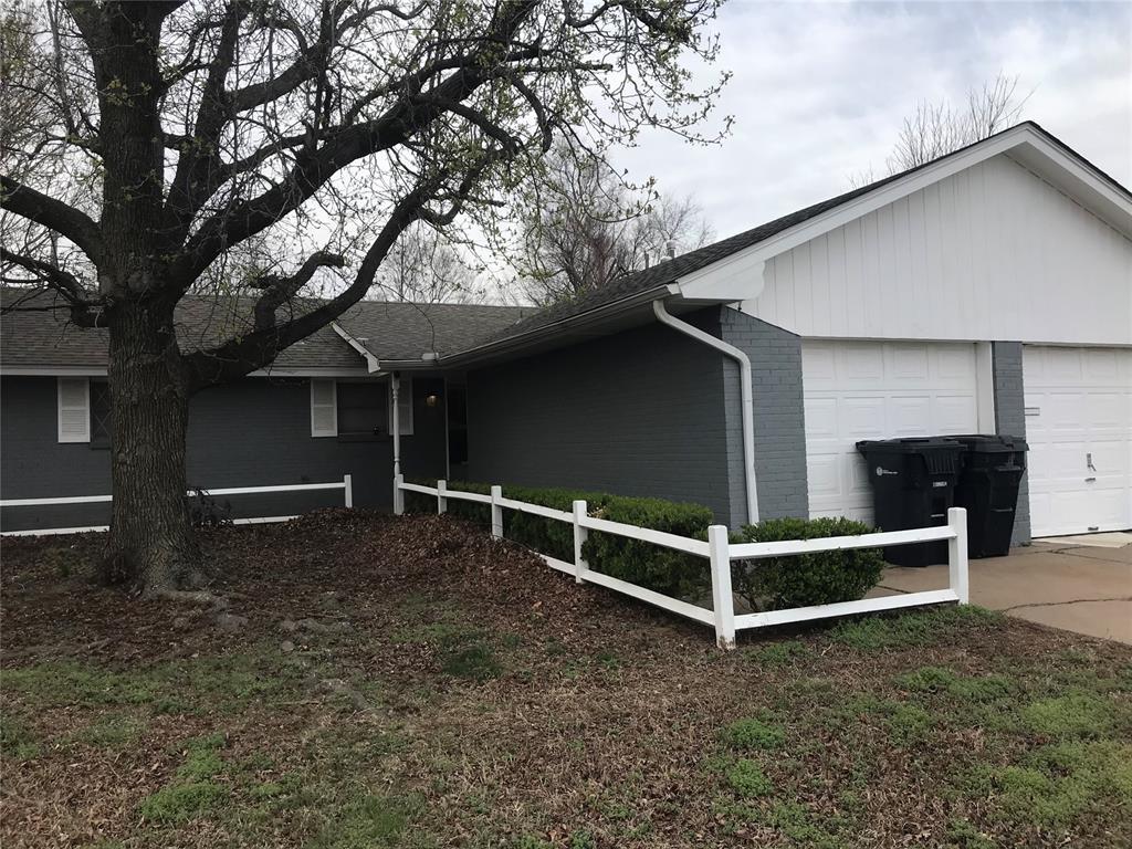 1310 SW 77th Ter, Oklahoma City, OK 73159 - view of front of home with brick siding, concrete driveway, an attached garage, and fence