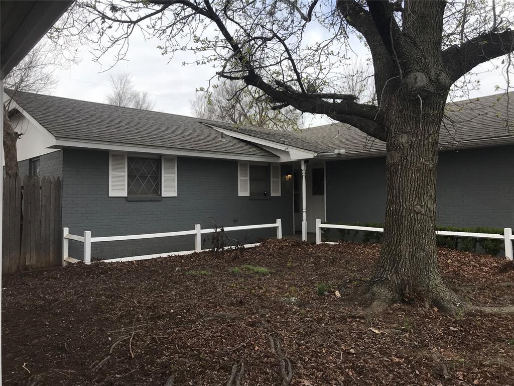 1310 SW 77th Ter, Oklahoma City, OK 73159 - view of front of house featuring brick siding, roof with shingles, and fence