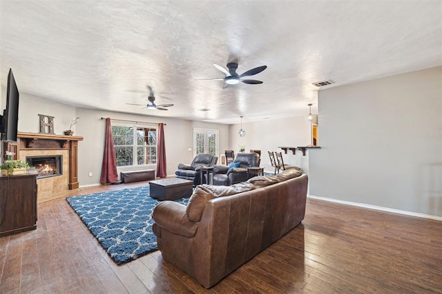 18761 Council Ave, Lindsay, OK 73052 - living room featuring hardwood / wood-style floors, a ceiling fan, a premium fireplace, and baseboards