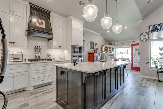 1624 NE 32nd St, Moore, OK 73160 - kitchen with light countertops, backsplash, appliances with stainless steel finishes, white cabinetry, and vaulted ceiling