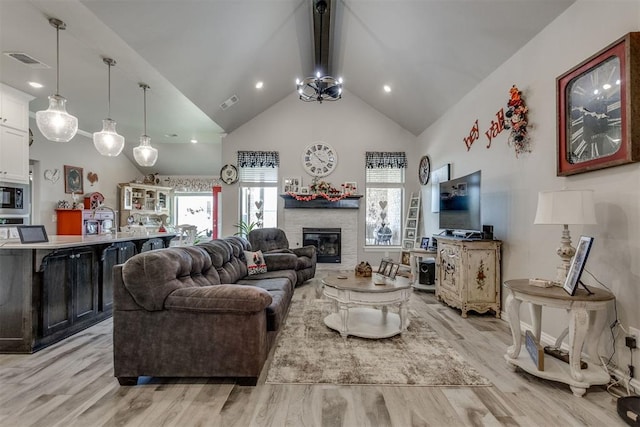 1624 NE 32nd St, Moore, OK 73160 - living area with high vaulted ceiling, light wood-type flooring, beamed ceiling, a stone fireplace, and recessed lighting