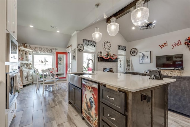 1624 NE 32nd St, Moore, OK 73160 - kitchen with stainless steel appliances, open floor plan, a fireplace, a center island with sink, and light countertops