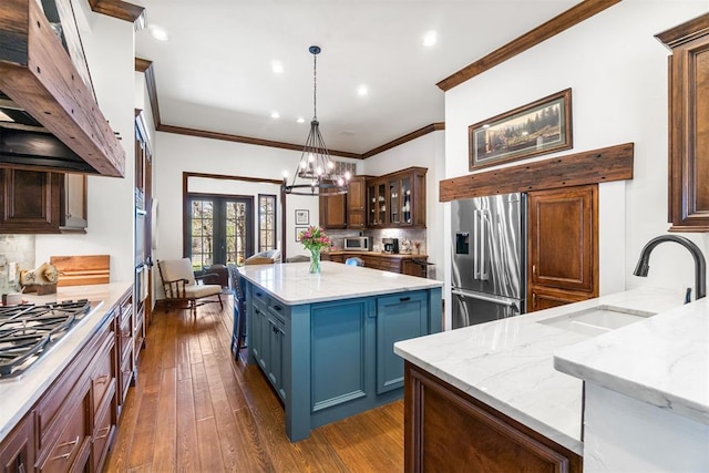 1514 Duxsford Ct, Edmond, OK 73034 - kitchen featuring appliances with stainless steel finishes, custom exhaust hood, backsplash, ornamental molding, and a chandelier