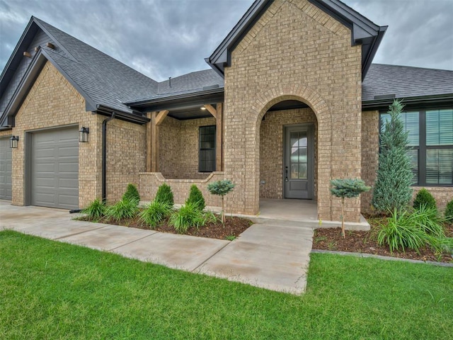 77 Orchid Ct, Piedmont, OK 73078 - view of front facade with brick siding, roof with shingles, an attached garage, and a front lawn