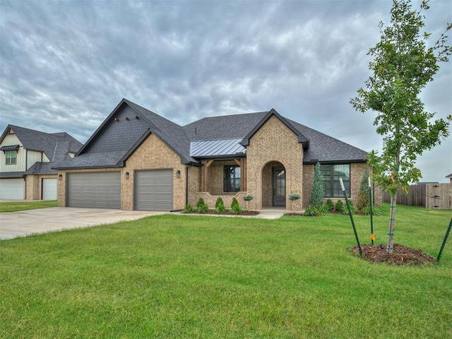 77 Orchid Ct, Piedmont, OK 73078 - view of front of property with brick siding, a garage, concrete driveway, and a standing seam roof