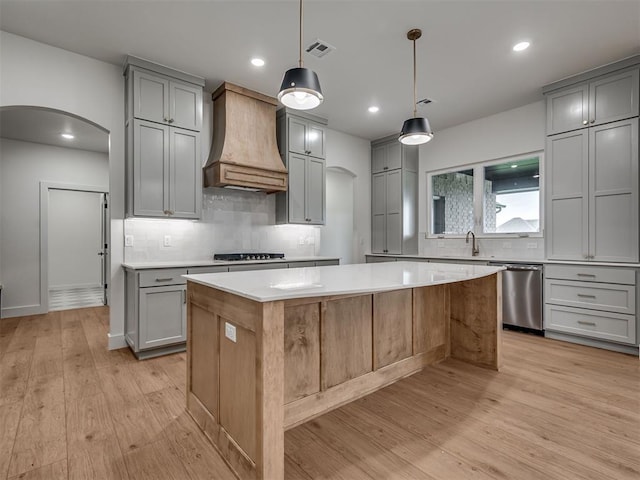 77 Orchid Ct, Piedmont, OK 73078 - kitchen featuring custom exhaust hood, dishwasher, gray cabinets, arched walkways, and a kitchen island